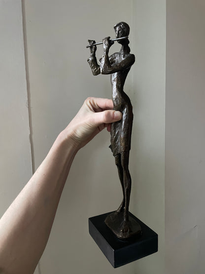 Sculpted Bronze Flutist in Windswept Dress on Black Podium